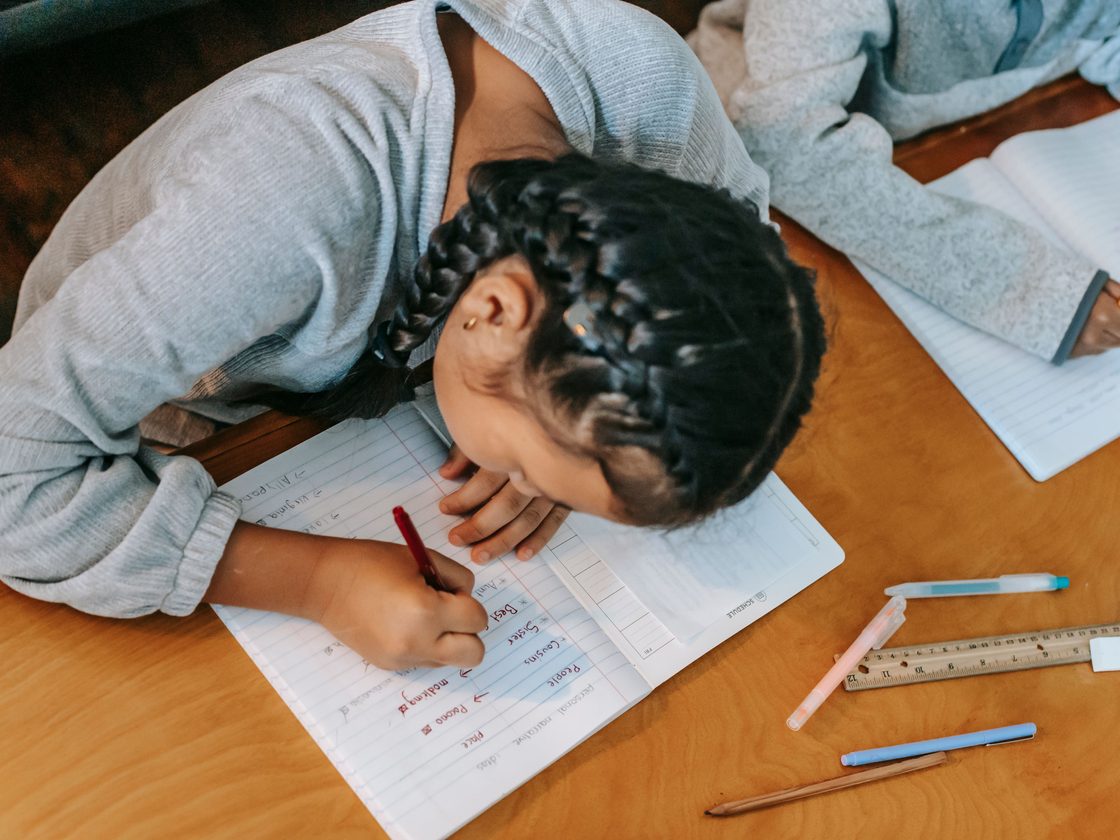 A student writing vocabulary words in a notebook.