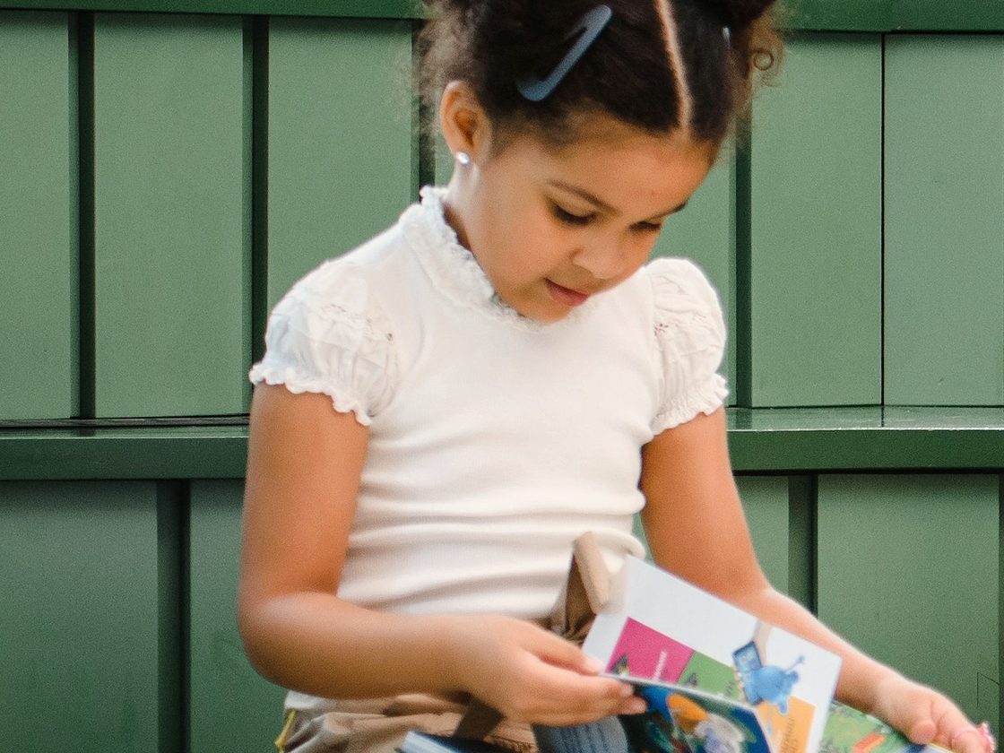 A young student reading a book.